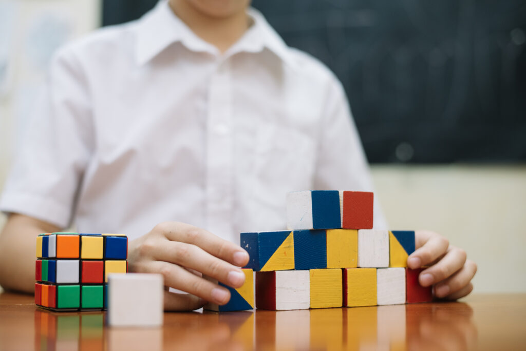 boy-playing-with-puzzles-desk